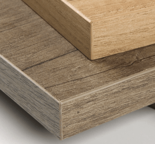 Close-up of wood-grain edgebanding on stacked cabinet panel edges